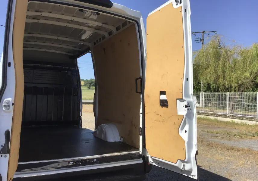 Vue arrière ouverte du fourgon blanc Iveco Daily 2022, montrant l'intérieur avec cloison bois et marchepied noir.