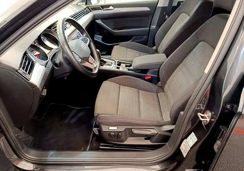 Intérieur avant droit de la Volkswagen Passat gris foncé, montrant sièges tissu et volant cuir multifonctions.