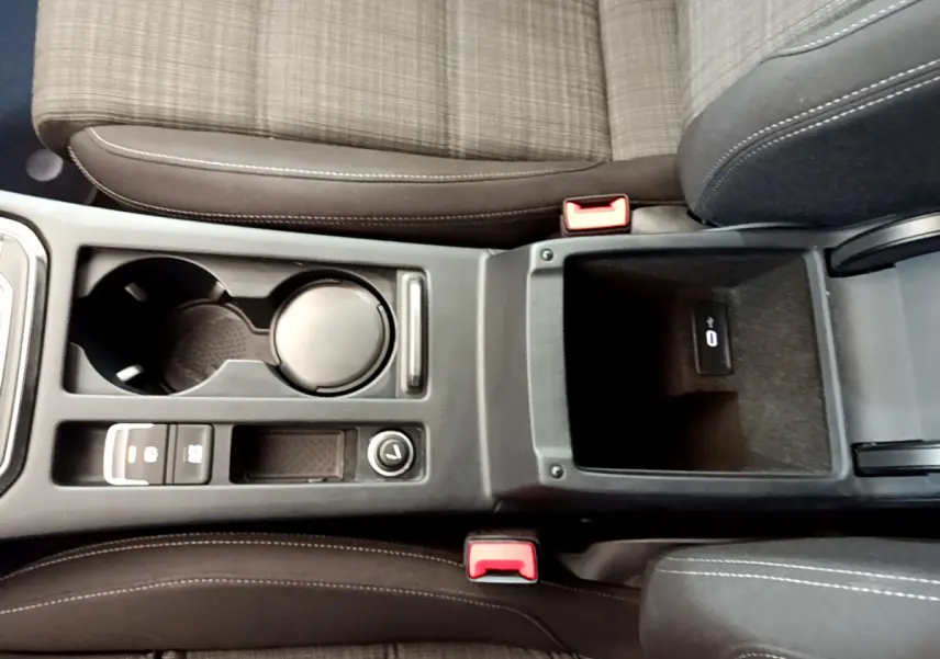 Vue plongeante sur la console centrale et les sièges avant en tissu gris de la Volkswagen Passat 2.0 TDI 2021.