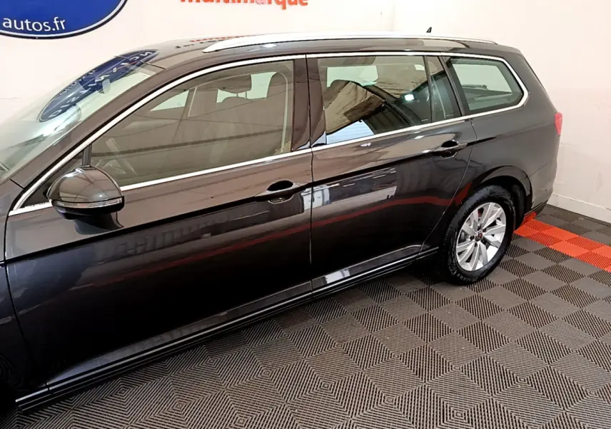 Profil côté gauche d'une Volkswagen Passat break gris foncé, avec jantes alliage et rétroviseurs électriques.