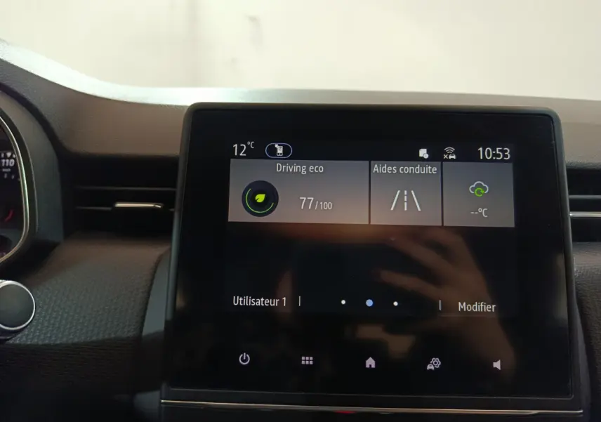 Écran tactile central de la Renault Clio Business blanc 2021 affichant l'aide à la conduite et la température extérieure.