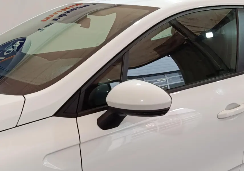 Vue rapprochée du rétroviseur côté gauche blanc d'une Renault Clio Business TCe 90 2021, avec porte et vitre teintée.