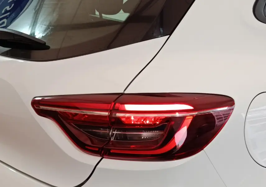 Gros plan sur le feu arrière droit rouge d'une Renault Clio Business blanche, mettant en valeur ses lignes modernes.