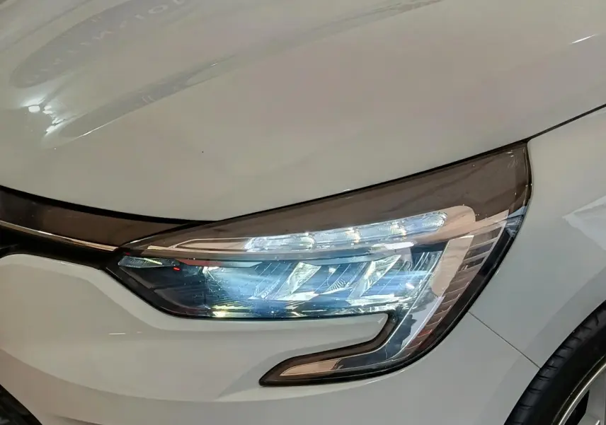 Gros plan sur le phare avant droit blanc d'une Renault Clio Business TCe 90 2021 avec LED et design moderne.