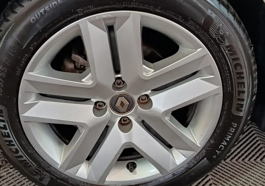 Gros plan sur la jante alliage argentée avec logo Renault au centre d'une Renault Clio blanche de 2021.