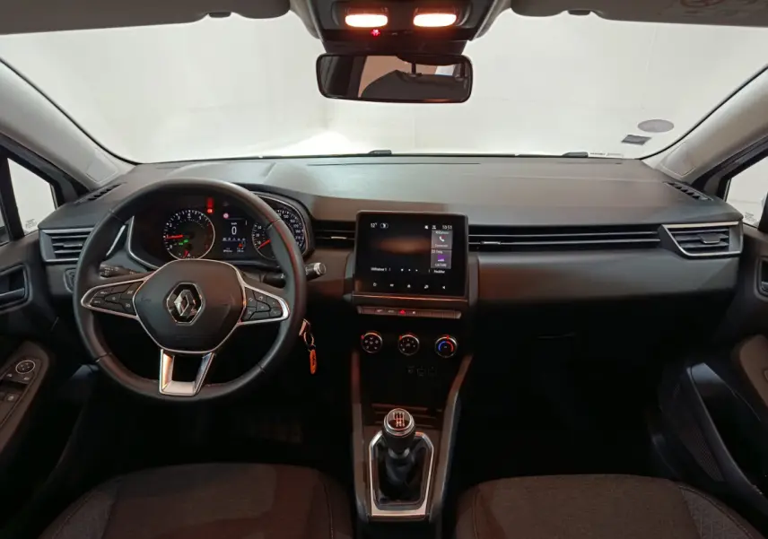 Vue intérieure avant de la Renault Clio Business TCe 90 2021, tableau de bord noir avec écran tactile central et volant multifonctions.