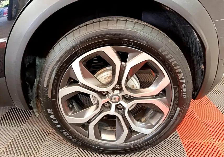 Vue rapprochée sur la roue arrière droite d'un Renault Captur noir, avec passage de roue gris et pneu visible.