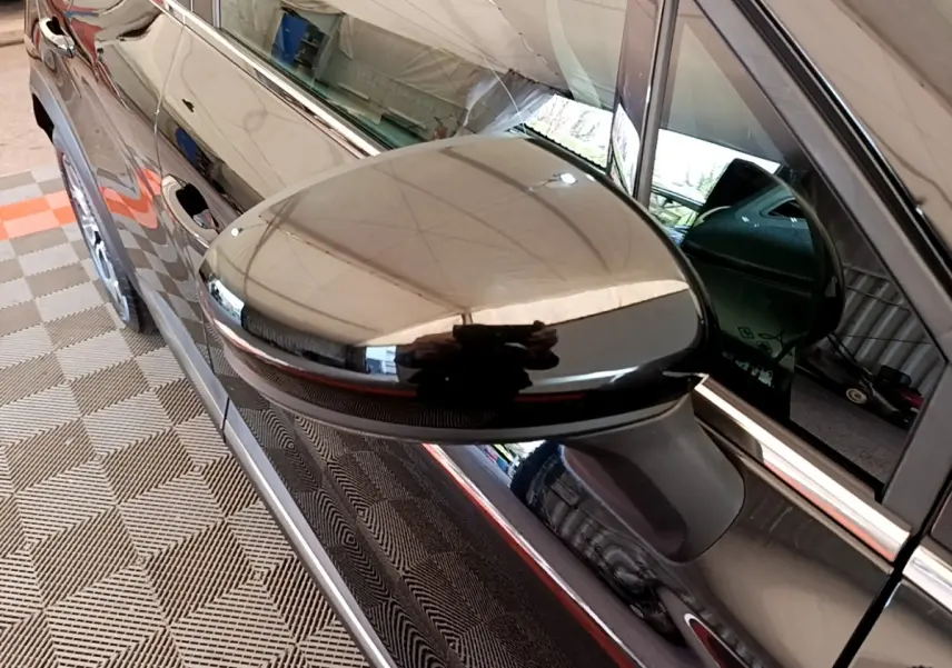 Gros plan sur le rétroviseur noir côté conducteur du Renault Captur Business Blue dCi 115 EDC 2021, reflet brillant.