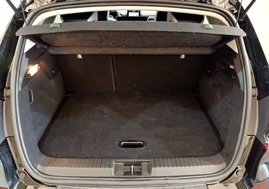Coffre ouvert vu de l'arrière d'un Renault Captur Business noir, montrant un espace de chargement propre et spacieux.