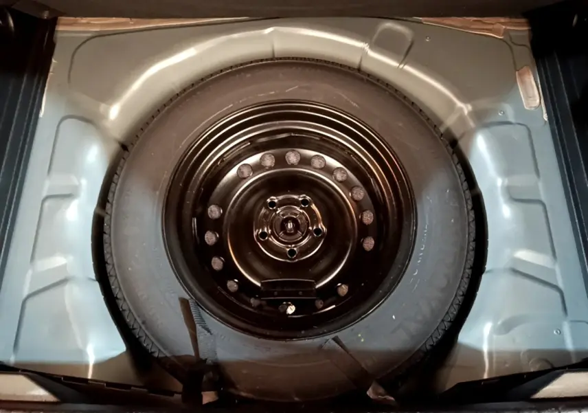 Roue de secours noire vue de dessus dans le coffre d’un Renault Captur Business Blue dCi 115 EDC 2021.