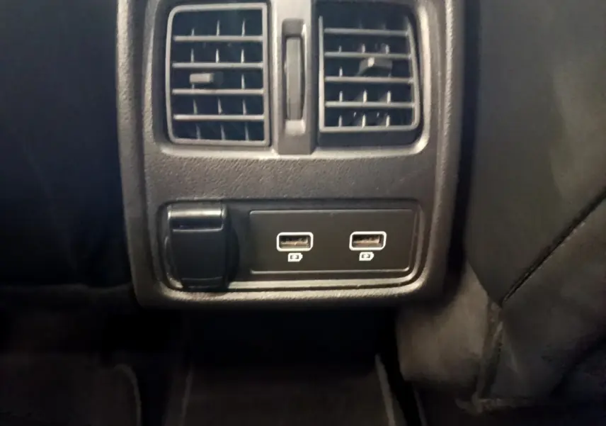 Détail intérieur montrant la prise 12V et deux ports USB sous les aérateurs arrière du Renault Captur noir Business 2021.