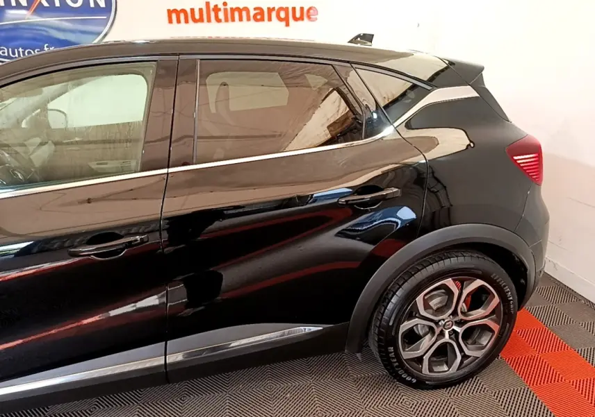 Profil côté droit du Renault Captur Business noir, mettant en valeur les lignes fluides et les poignées de porte intégrées.