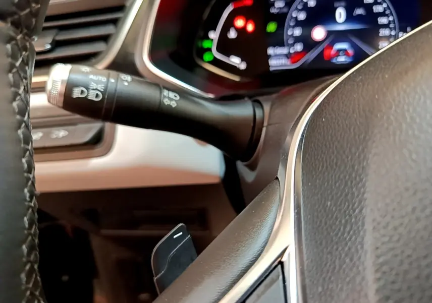 Gros plan sur le volant noir et la commande des phares du tableau de bord du Renault Captur Business 2021.