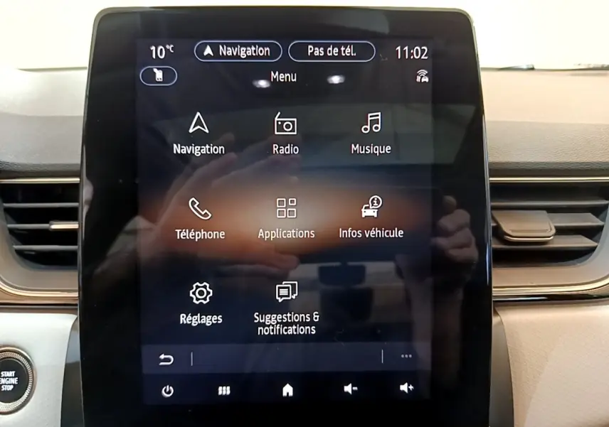 Écran tactile central du tableau de bord du Renault Captur Business noir, affichant le menu principal de navigation et multimédia.