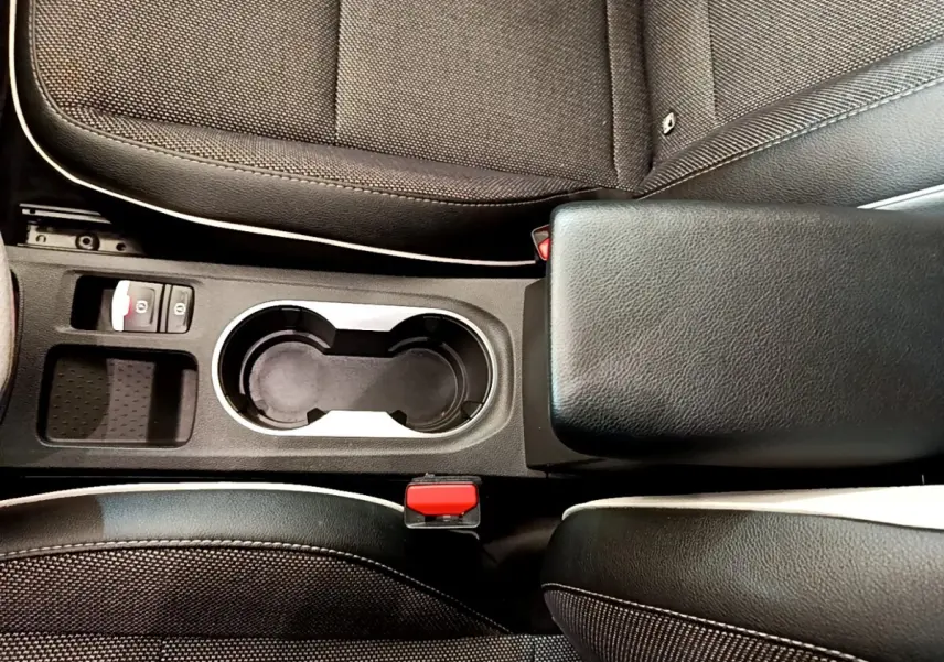 Vue plongeante sur la console centrale noire du Renault Captur 2021, avec porte-gobelets et accoudoir cuir.