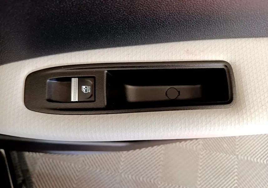 Gros plan sur le bouton de commande de vitre électrique côté conducteur du Renault Captur noir 2021.