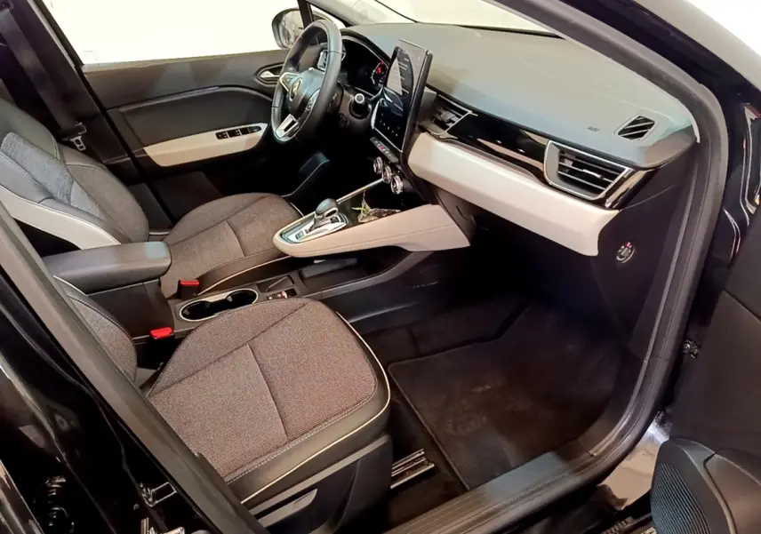 Vue intérieure côté passager du Renault Captur Business noir, avec tableau de bord beige et écran tactile vertical.