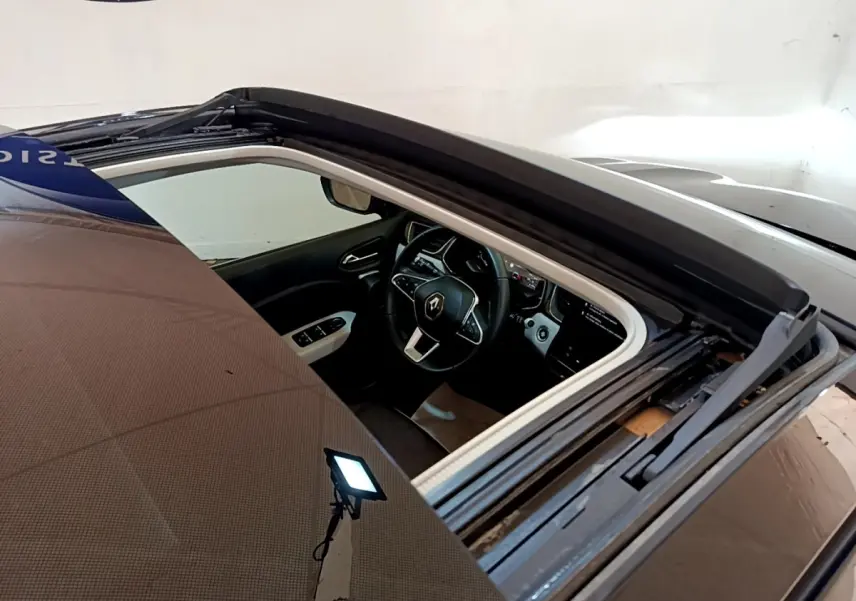 Vue plongeante sur l'intérieur noir du Renault Captur Business 2021, mettant en valeur le volant multifonctions et l'écran tactile.