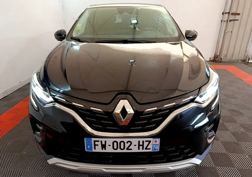 Vue avant rapprochée du Renault Captur Business noir, mettant en valeur la calandre chromée et les phares LED allumés.