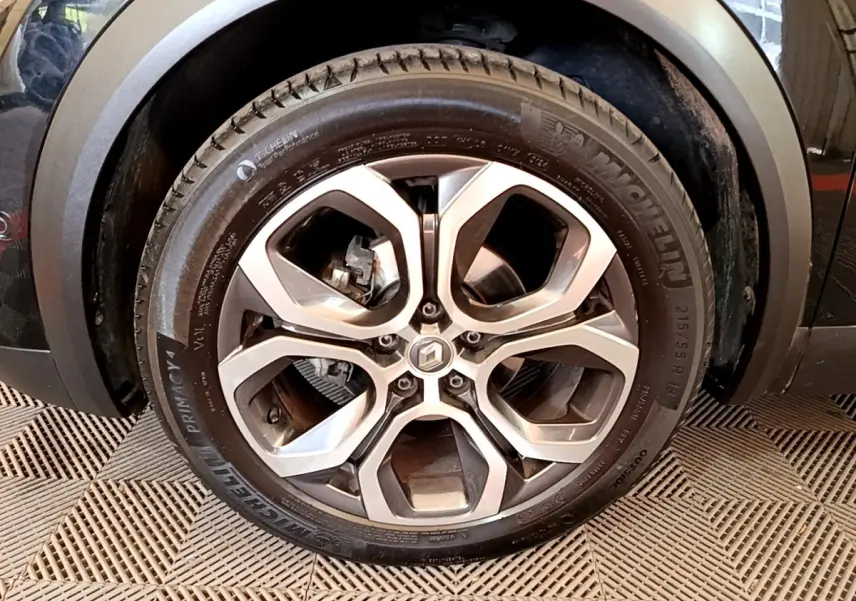 Gros plan sur la roue avant gauche du Renault Captur noir, mettant en valeur la jante alliage et le pneu Michelin.