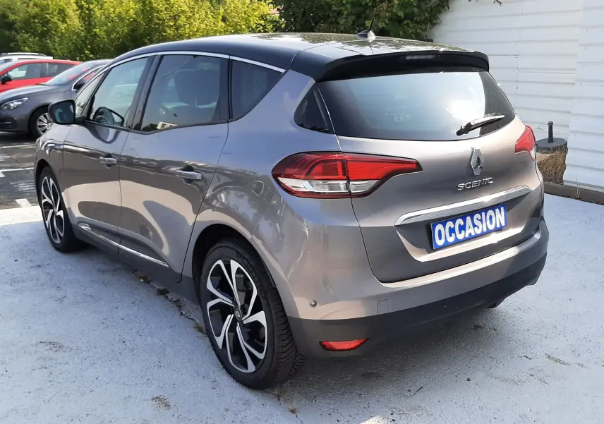Renault Scénic IV gris cassiopée toit noir en 3/4 arrière droit, avec jantes alliage et feux arrière LED visibles.