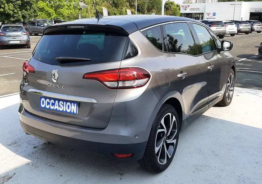 Vue 3/4 arrière droite du Renault Scénic IV gris Cassiopée avec toit noir, jantes alliage et feux arrière LED.