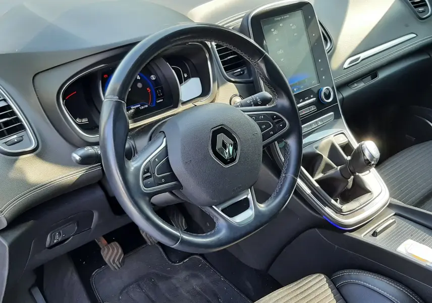 Vue intérieure côté conducteur du Renault Scénic IV 1.6 DCI 130 Intens, volant cuir, écran tactile vertical et levier de vitesse manuel.