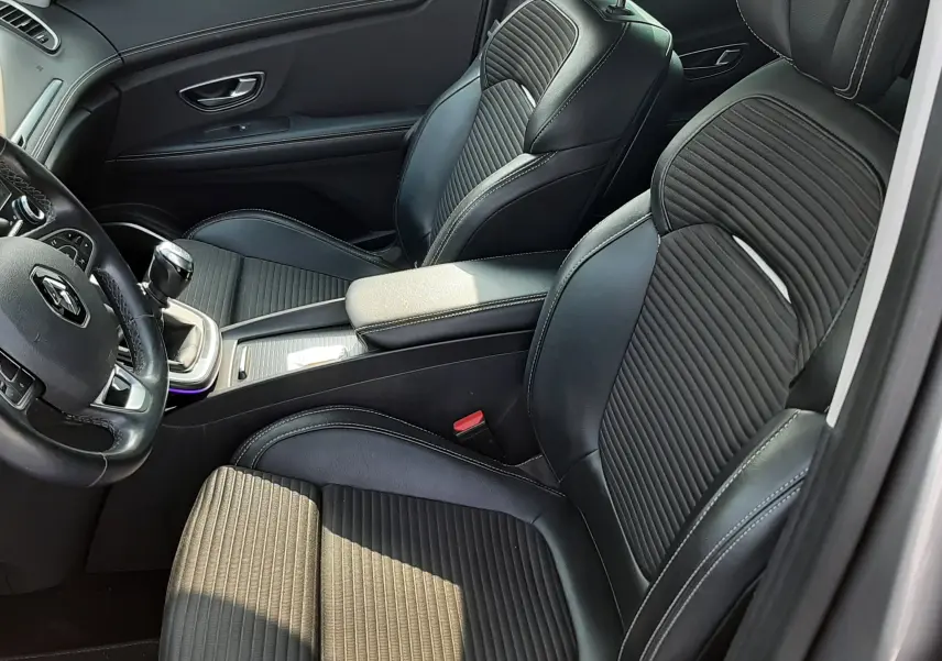 Vue intérieure côté conducteur du Renault Scenic IV 1.6 DCI 130 Intens Bose, sièges noirs en cuir et tissu avec surpiqûres blanches.