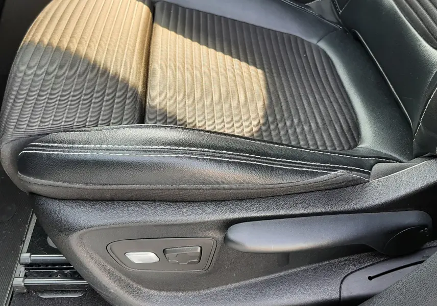 Gros plan sur le siège avant droit en cuir et tissu noir du Renault Scénic IV 2018, avec commandes électriques visibles.