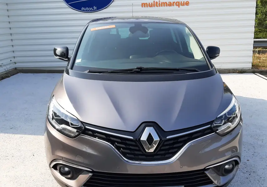 Vue avant d'un Renault Scénic IV gris Cassiopée avec toit noir, affichant un panneau "OCCASION" sur le pare-chocs.