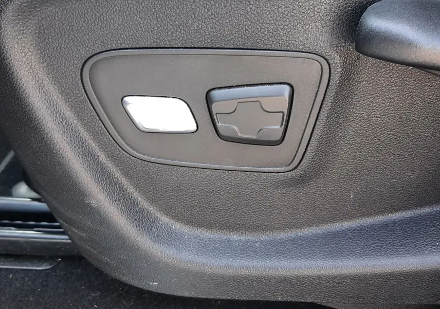 Gros plan sur les commandes de réglage électrique du siège côté conducteur du Renault Scenic IV gris cassiopée.