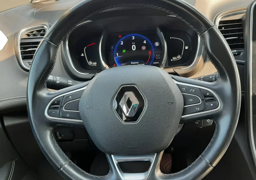 Vue intérieure centrée sur le volant noir du Renault Scénic IV 2018 avec tableau de bord numérique allumé.