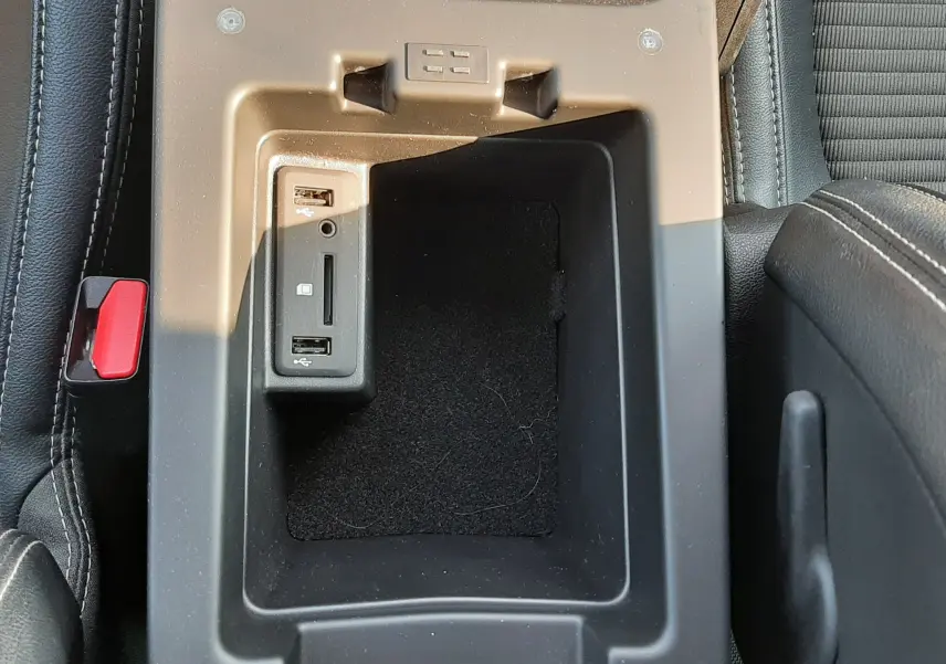 Vue plongeante sur la console centrale noire du Renault Scénic IV avec ports USB et lecteur de carte SD intégrés.