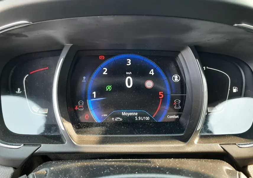 Vue rapprochée du tableau de bord numérique du Renault Scenic IV, affichant le compte-tours et la consommation moyenne.
