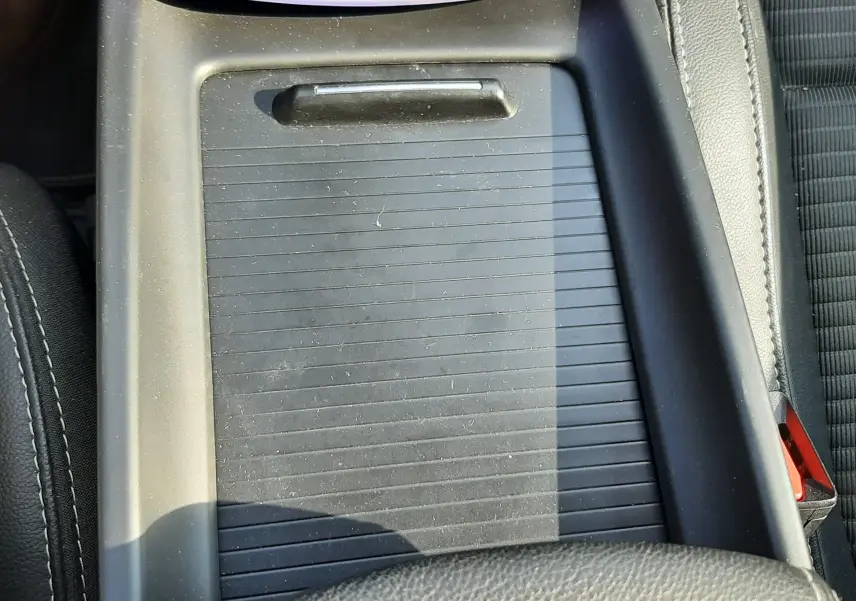 Gros plan sur la console centrale noire du Renault Scénic IV 1.6 DCI 130 Intens Bose avec accoudoir en cuir.