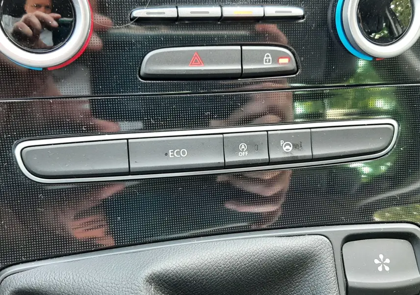 Vue rapprochée de la console centrale noire brillante du Renault Scénic IV 1.6 DCI 130 Intens avec commandes climatisation et bouton ECO.