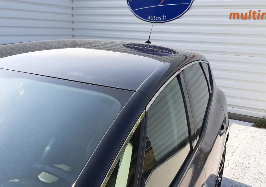 Vue plongeante sur l'arrière droit du Renault Scénic IV gris Cassiopée avec toit noir brillant et antenne courte.