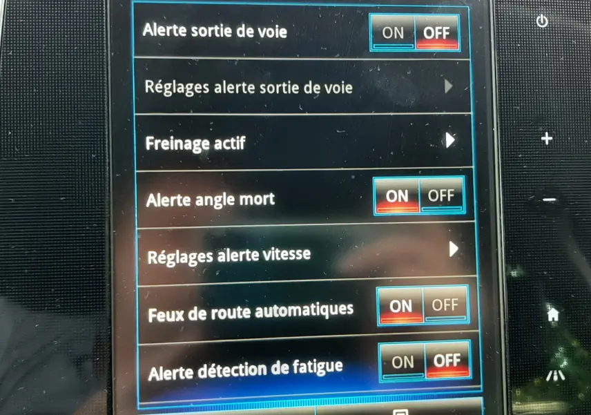 Écran tactile du tableau de bord du Renault Scénic IV montrant les réglages des aides à la conduite.