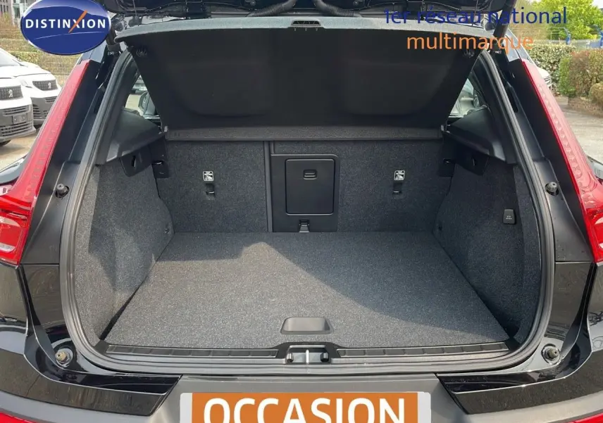 Coffre ouvert d'un Volvo XC40 noir Onyx Metal vu de l'arrière, montrant l'espace de chargement vide et la finition intérieure grise.