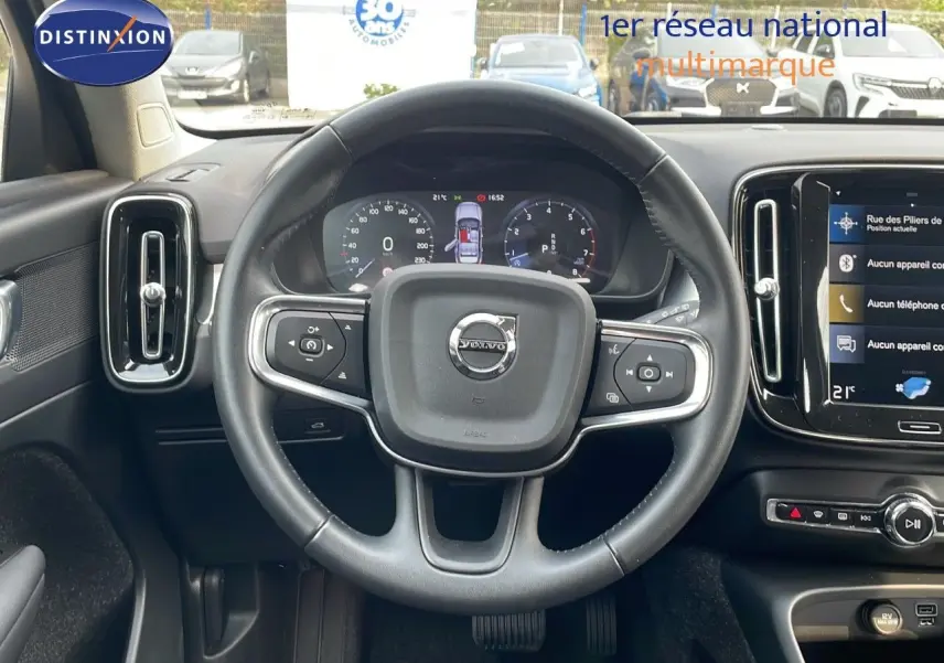 Vue intérieure centrée sur le volant du Volvo XC40 noir Onyx Metal, avec tableau de bord numérique et écran tactile.