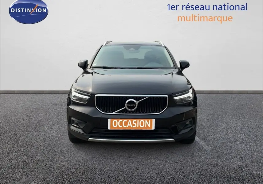 Vue frontale d'un Volvo XC40 noir Onyx Metal avec calandre chromée et phares LED allumés.