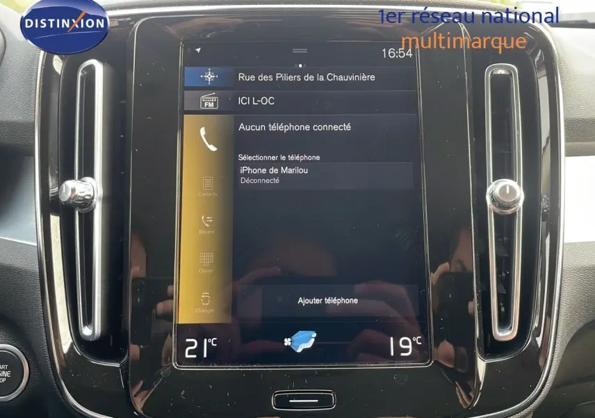 Écran tactile central du tableau de bord du Volvo XC40 noir Onyx Metal, affichant les réglages de téléphone et climatisation.