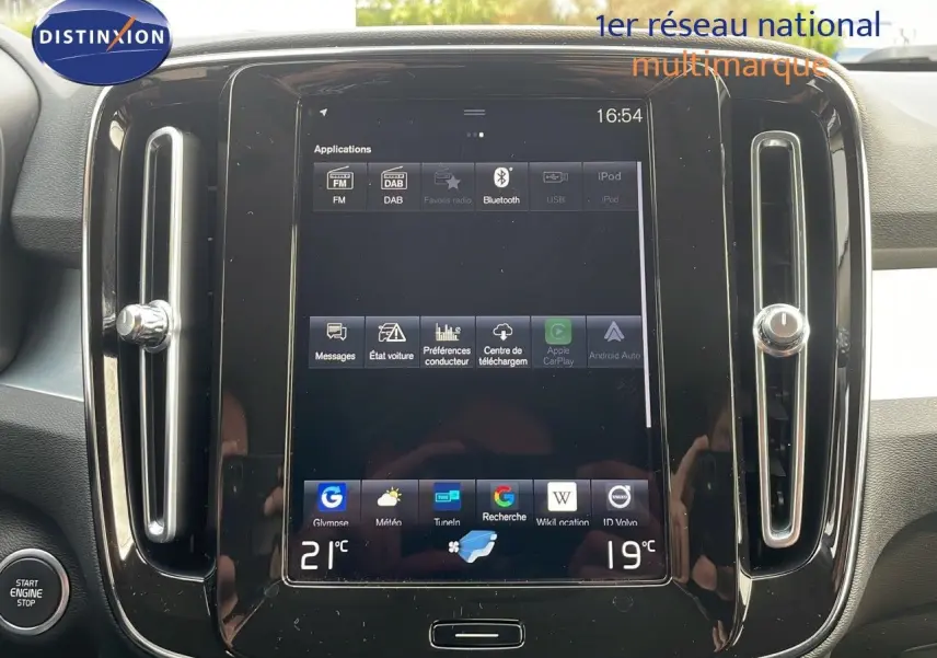 Vue rapprochée de l’écran tactile central du Volvo XC40 noir Onyx Metal, affichant les applications multimédia et la climatisation.