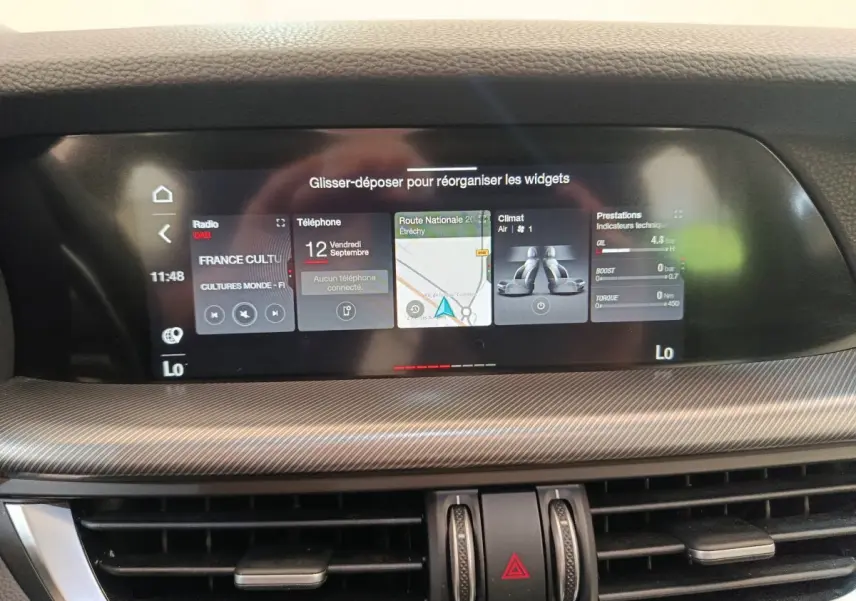 Écran tactile central affichant navigation et climatisation dans l'habitacle d'une Alfa Romeo Stelvio 2024.