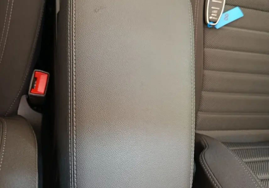 Vue plongeante sur l'accoudoir central en cuir noir et la clé de l'Alfa Romeo Stelvio Sprint 2024 gris foncé.