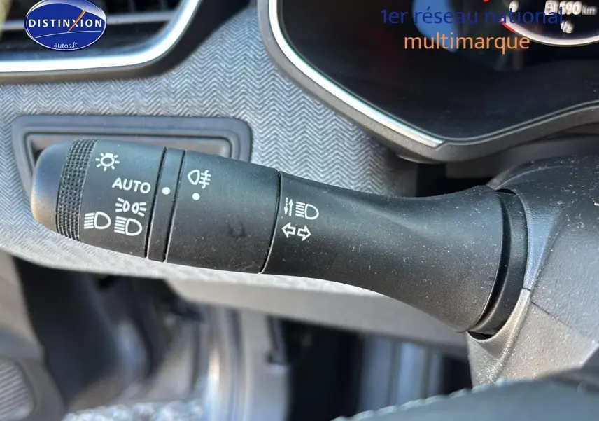 Le commodo des phares et clignotants sur le côté gauche du tableau de bord d'une Renault Clio V gris pizzara.