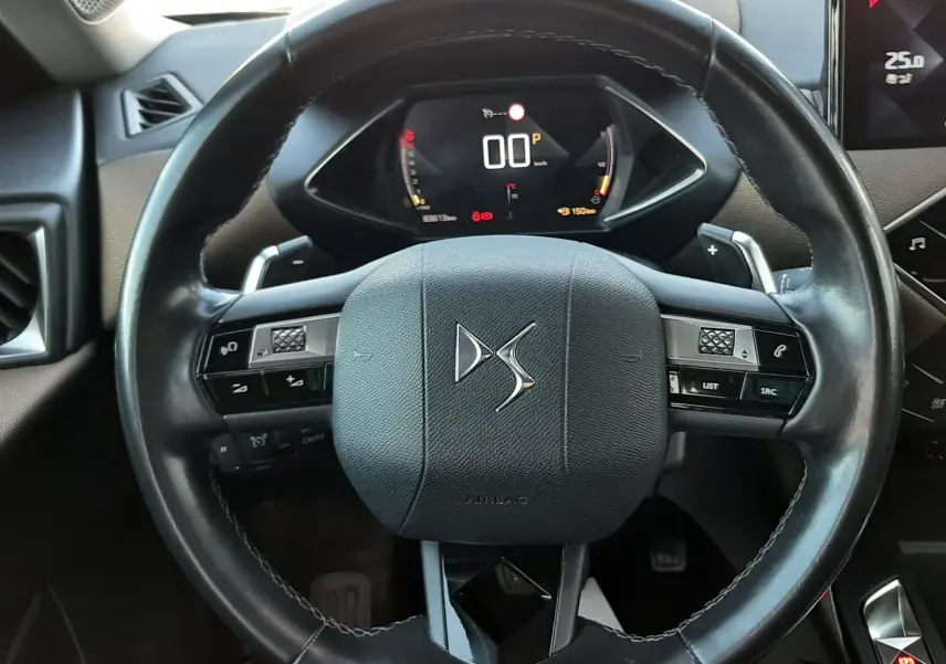 Vue rapprochée du volant en cuir noir avec logo DS, tableau de bord numérique et partie de l’écran central du DS3 Crossback 2019.