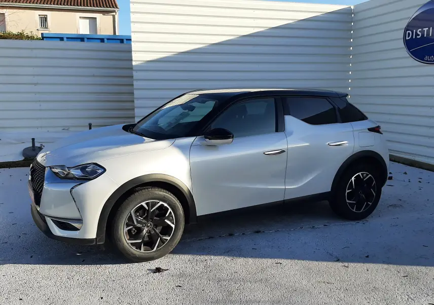 Vue 3/4 avant droit d'un DS3 Crossback blanc perle avec toit noir et jantes noires en alliage.