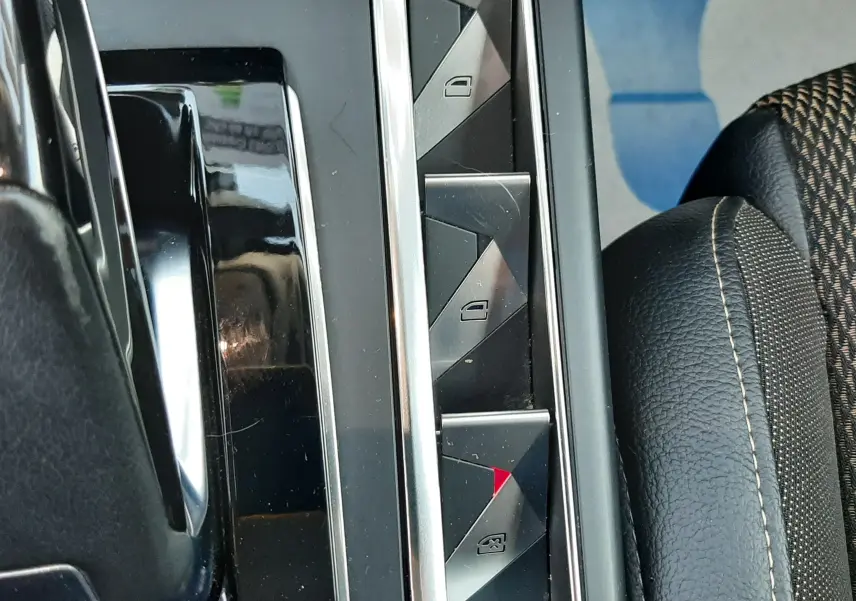 Gros plan sur les commandes de lève-vitres et verrouillage central, avec sellerie noire et tissu à motifs sur DS3 Crossback.