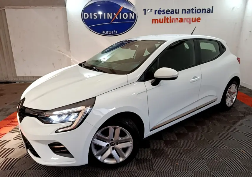 Renault Clio Business TCe 90 blanche vue en 3/4 avant droit avec phares LED allumés en showroom